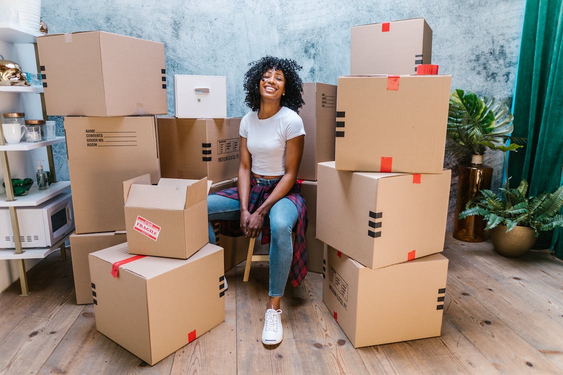 girl sitting between moving boxes